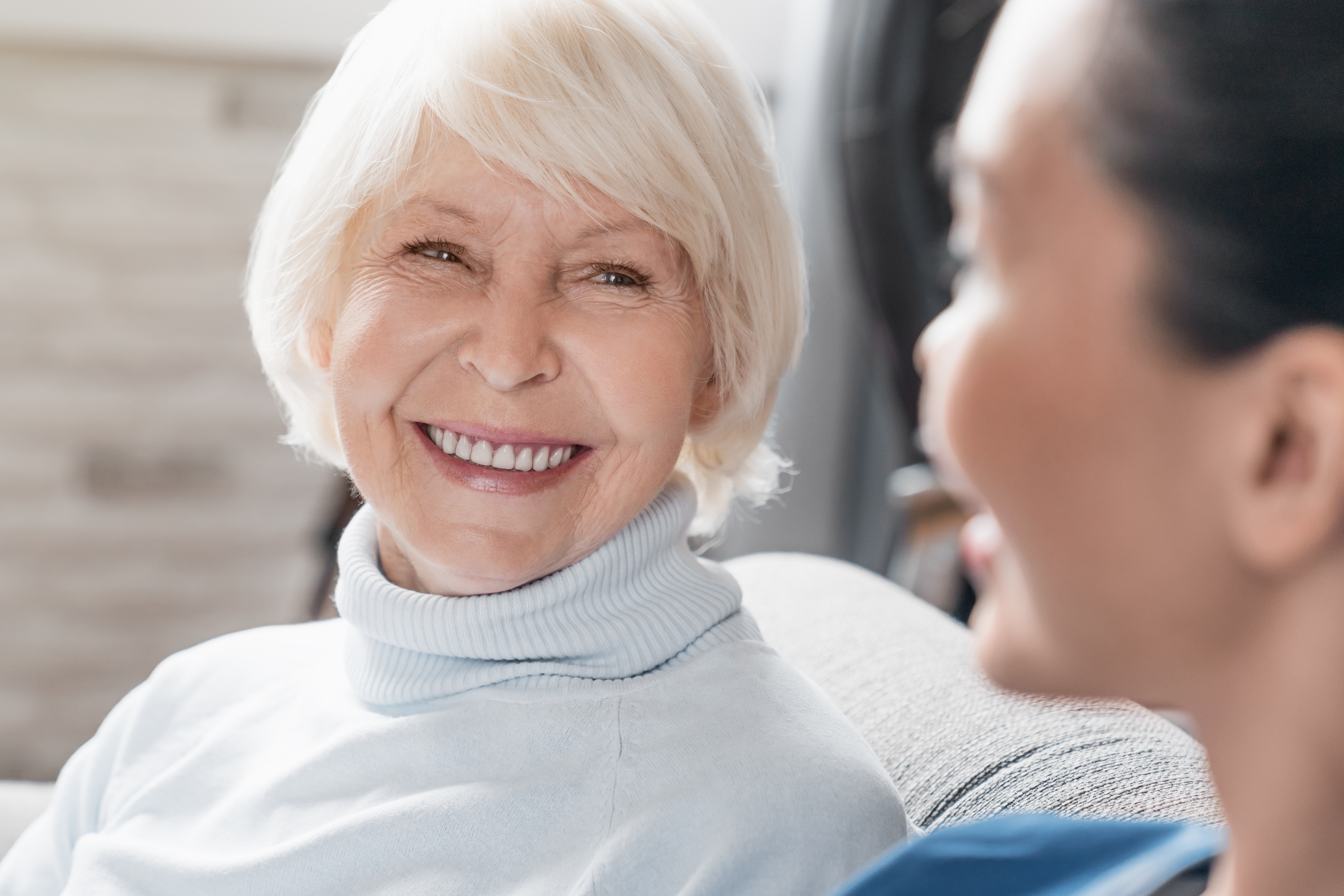 Augenärztin untersucht einen älteren Patienten an einem Diagnostikgerät